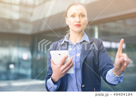 Adult woman with tablet pointing finger on air Adult woman with tablet pointing finger on air 49404184