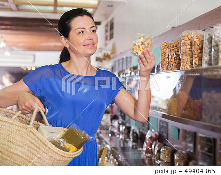 Customer choosing candied fruits 49404365
