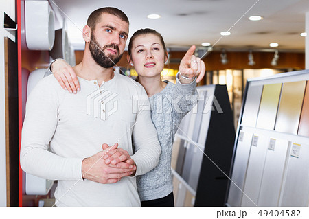 Smiling family couple standing and point with finger to tile Smiling family couple standing and point with finger to tile 49404582