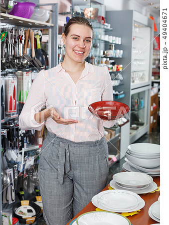 Young woman consumer ceramic plates in tableware shop Young woman consumer ceramic plates in tableware shop 49404671