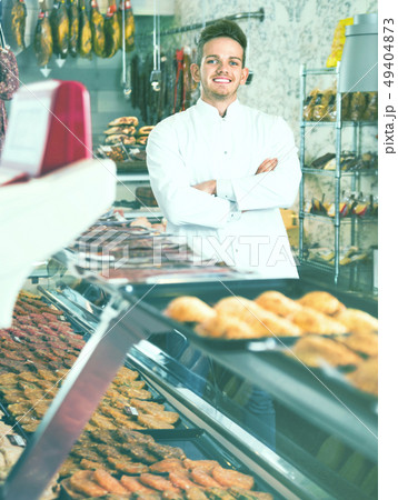 Assistant in grocery shop greeting customers Assistant in grocery shop greeting customers 49404873