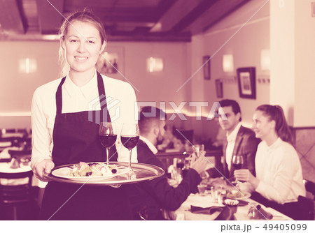 Smiling waitress with serving tray Smiling waitress with serving tray 49405099