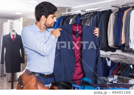 Male is choosing jacket Male is choosing jacket 49405100