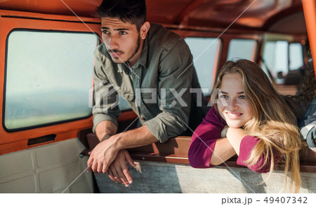 A group of young friends on a roadtrip through countryside, looking out of window. A group of young friends on a roadtrip through countryside, looking out of window. 49407342