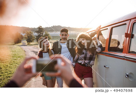 A group of friends with smartphone on a roadtrip through countryside, taking photo. A group of friends with smartphone on a roadtrip through countryside, taking photo. 49407698