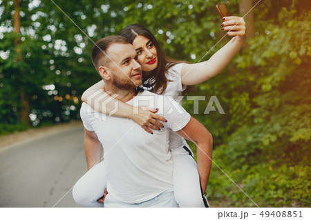 Beautiful couple spend time in a summer park Beautiful couple spend time in a summer park 49408851