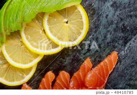 Raw salmon with lemon and avocado on marble plate Raw salmon with lemon and avocado on marble plate 49410785