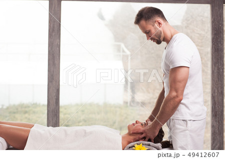 handsome smiling masseur doing massage 49412607