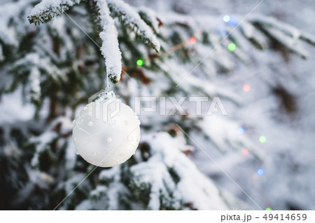 Close-up of a Christmas toy on a snow-covered lively tree in the winter forest on the background of Close-up of a Christmas toy on a snow-covered lively tree in the winter forest on the background of 49414659
