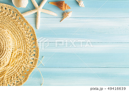 Top view of sea straw hat and sea shells on a blue Top view of sea straw hat and sea shells on a blue 49416639