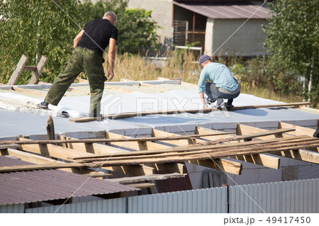 Workers cut the roof in the house Workers cut the roof in the house 49417450