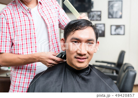 Barber cutting man's hair 49420857