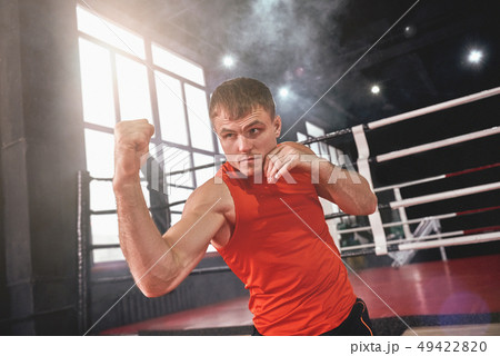 Training to become the best. Focused muscular athlete in sports clothing boxing with shadow while Training to become the best. Focused muscular athlete in sports clothing boxing with shadow while 49422820