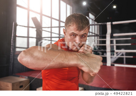Power hook - rough bruiser. Close-up of focused muscular athlete in sports clothing looking at Power hook - rough bruiser. Close-up of focused muscular athlete in sports clothing looking at 49422821