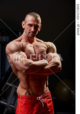 Athletic man posing. Photo of man with perfect physique on black background. Strength and motivation 49425869