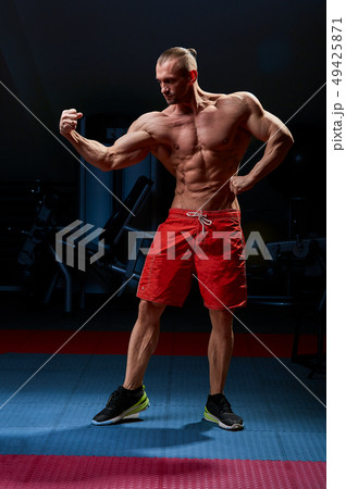 Athletic man posing. Photo of man with perfect physique on black background. Strength and motivation Athletic man posing. Photo of man with perfect physique on black background. Strength and motivation 49425871
