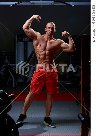 Athletic man posing. Photo of man with perfect physique on black background. Strength and motivation 49425888