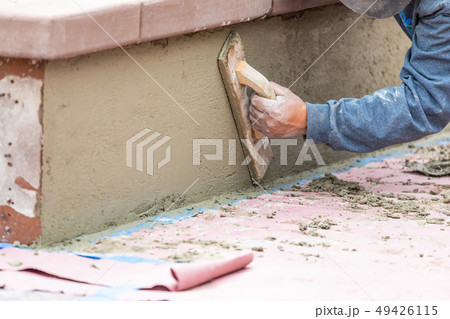 Worker Smoothing Cement with Wooden Float 49426115