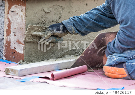 Tile Worker Applying Cement with Trowel on a Wall 49426117