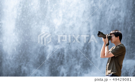 Asian male traveler taking photo at waterfall 49429081