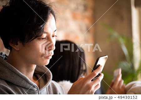 スマホを見るカップル　ライフスタイル 49430152