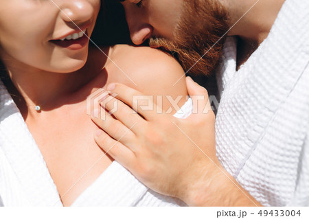 Young man gently kissing beautiful woman on shoulder Young man gently kissing beautiful woman on shoulder 49433004