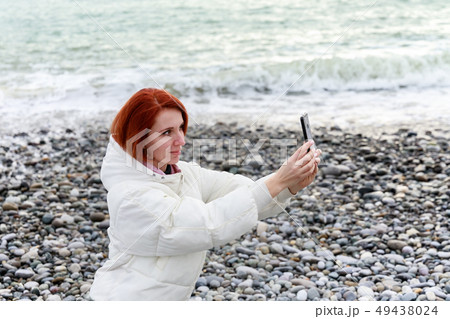 Young woman photographs herself on the phone 49438024