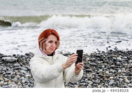 Young woman photographs herself on the phone Young woman photographs herself on the phone 49438026