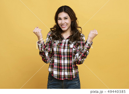 Portrait surprised happy asian woman on yellow 49440385