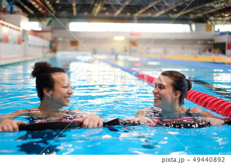 Multiracial couple attending water aerobics class in a swimming pool Multiracial couple attending water aerobics class in a swimming pool 49440892