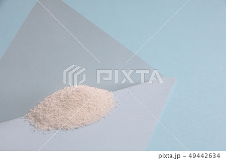 薬包紙にのせられた白い粉。分析・実験等のイメージ。(撮影に使用した白い粉はクリーミングパウダー) 49442634