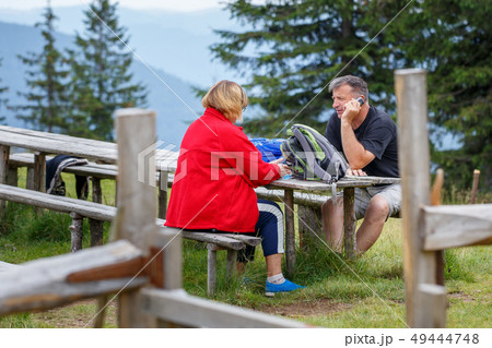 Mature Man and woman resting at camp in mountains Mature Man and woman resting at camp in mountains 49444748