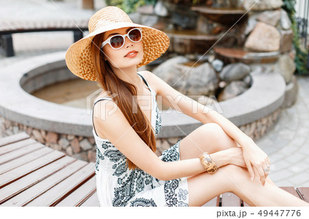 Young beautiful girl in sunglasses and straw hat Young beautiful girl in sunglasses and straw hat 49447776