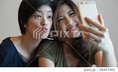 Two mixed race Asian girls selfie smart phone 49447802