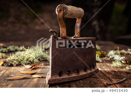 Old rusty iron on a rustic wooden table. Ironing. Old rusty iron on a rustic wooden table. Ironing. 49453430