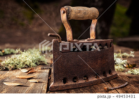 Old rusty iron on a rustic wooden table. Ironing. Old rusty iron on a rustic wooden table. Ironing. 49453431