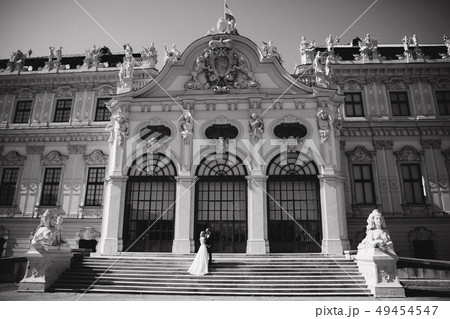Groom and bride stand on stairs by the great palace in Wiena 49454547