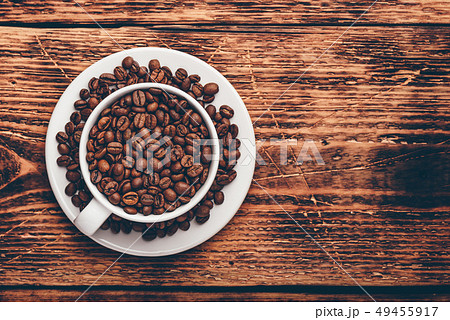White cup full of roasted coffee beans White cup full of roasted coffee beans 49455917