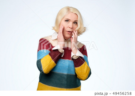 senior blonde woman saying wow  49456258