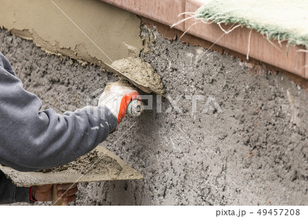 Tile Worker Applying Cement with Trowel at Pool Tile Worker Applying Cement with Trowel at Pool 49457208