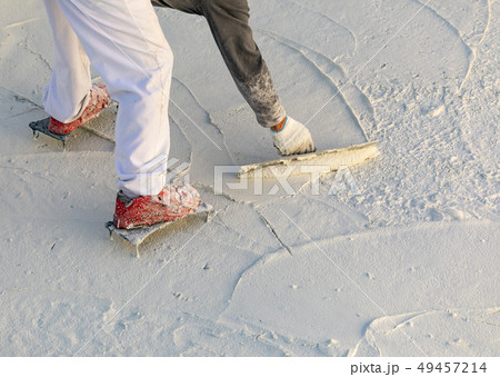 Worker Wearing Spiked Shoes Smoothing Pool Cement 49457214