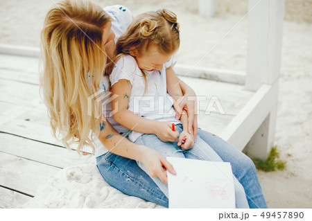 Mother with daughter drawing in a park Mother with daughter drawing in a park 49457890