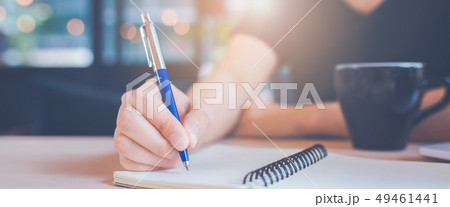Woman hand is writing on a notebook with a pen Woman hand is writing on a notebook with a pen 49461441