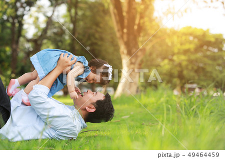 Father and little girl play lying on grass, low 49464459