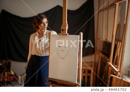 Cute female artist drawing in studio 49465702
