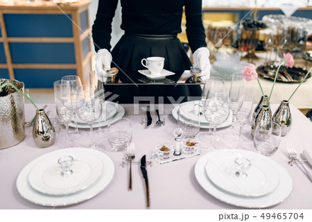 Waitress with tray puts the dishes, table setting 49465704