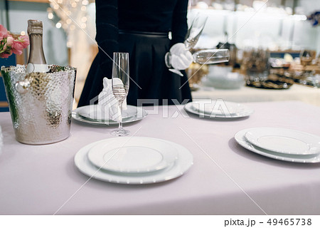 Waitress puts glasses for dining, table setting Waitress puts glasses for dining, table setting 49465738