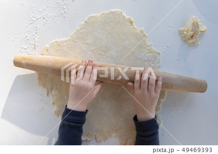 Boy's hands rolling dough 49469393