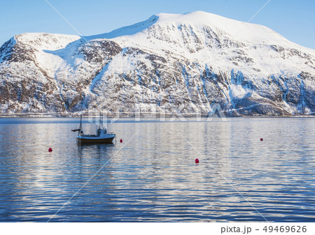 Fishing boat by snow covered mountain in Tromso, Norway 49469626