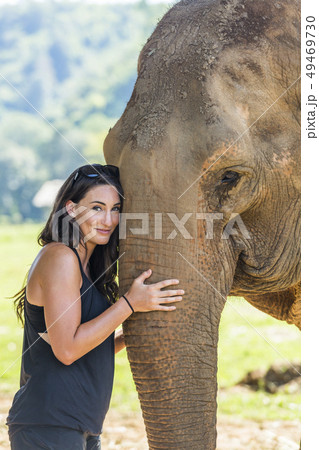 Woman holding trunk of Indian elephant in Chiang Mai, Thailand 49469730